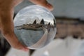 Opera house with cloudy sky photography in clear crystal glass ball with left hand male holding.